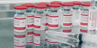 小瓶covid-19疫苗旁边有一个注射器