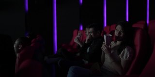 亚洲华裔年轻女子和朋友在电影院看恐怖电影