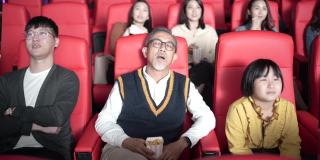 亚洲华人老人和孙女在电影院看电影睡着了