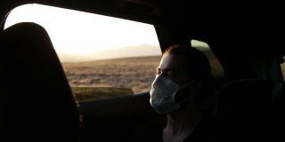 在隔离城市，一名男子在开车时戴着医用口罩。