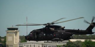 在军事演习中，一架美国军用直升机在美军基地上空以慢动作飞行。