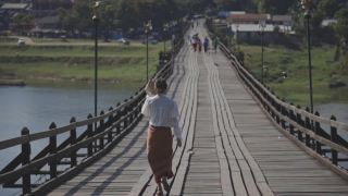 女人走在僧伽拉布里的桥上，北碧里美丽的日出视频素材模板下载