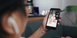 老奶奶在家用智能手机与孙辈视频通话。