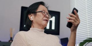老奶奶在家用智能手机与孙辈视频通话。