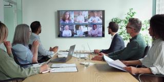 各种员工在会议室的电视屏幕上进行在线会议和视频通话。