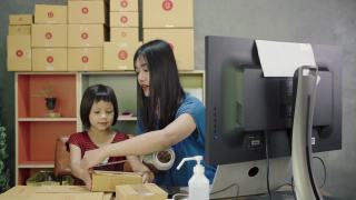 亚洲妇女和小女孩展示和包装盒集装箱网上销售在家里。视频素材模板下载