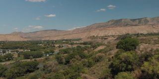 夏末无人机查看科罗拉多河流域农业绿地和水处理和BookCliff山脉4K视频系列