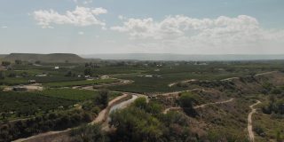 夏末无人机查看科罗拉多河流域农业绿地灌溉运河和BookCliff山脉4K视频系列