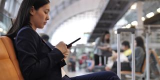 一个女人在机场用智能手机