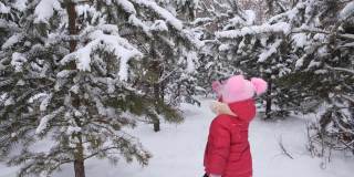 冬天，小女孩在公园里玩耍，在雪地里蹦蹦跳跳，打滚，抖落树枝上的雪