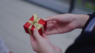 收手送红礼盒节日快乐新年圣诞快乐节日。给家人、爱人和朋友的礼物。庆祝活动中的有趣活动。给无家可归的人捐赠礼物。交付的业务视频素材模板下载