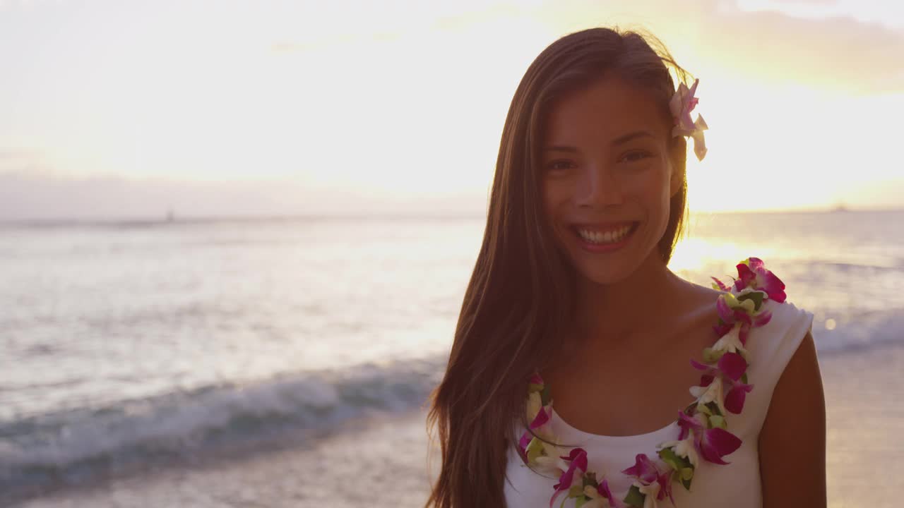 夏威夷-海滩女孩微笑笑在夏威夷怀基基海滩穿着蕾花花环在夏威夷海滩上玩。美丽的混血亚洲白种人妇女享受日落在瓦胡岛，夏威夷，美国