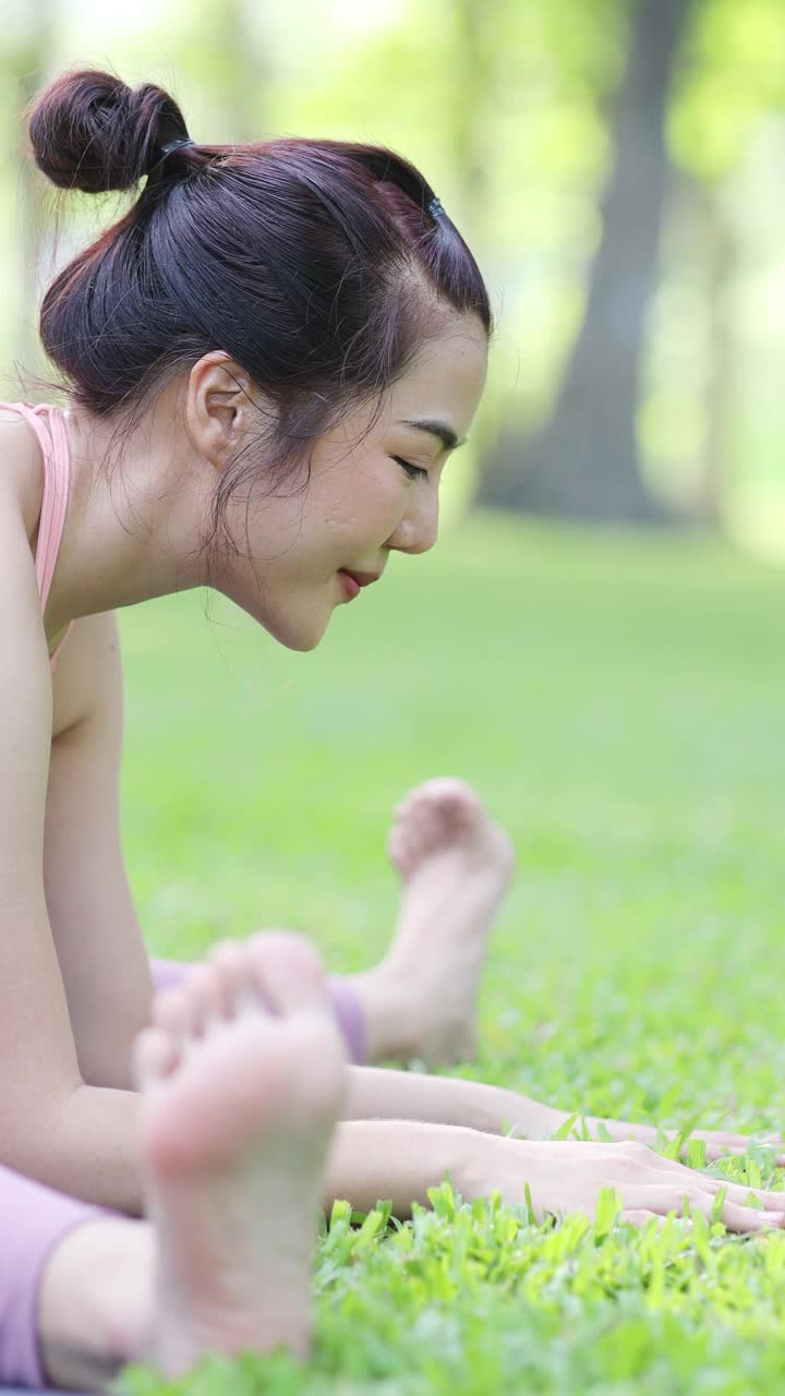 年轻的成年亚洲妇女在花园里自我练习瑜伽