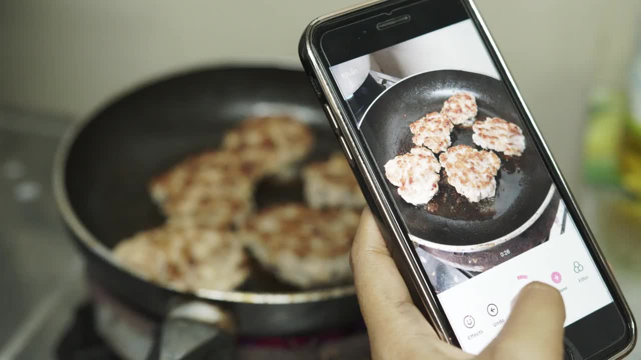 女人拿着现代智能手机，拍下美食照片，在社交媒体资源上分享。