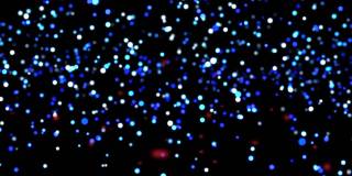 动画的红色能量粒子移动的蓝色和白色光点上升的黑色背景