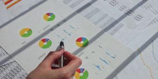 市场营销人员分析SEO图表和图表的手，市场报告，特写