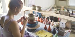女陶工绘画和上釉陶罐精密使用特殊工具