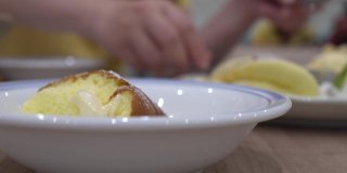 餐厅木桌上的煎饼特写。盘子里有奶油和冰淇淋。把煎饼分装到其他盘子里。