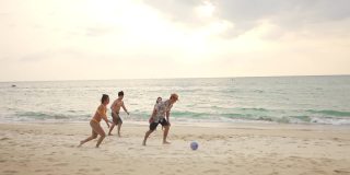 一群亚洲男人和女人朋友一起玩海滩足球