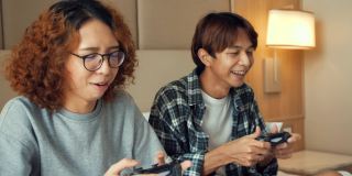 两个青少年在他们的房间里玩电子游戏。