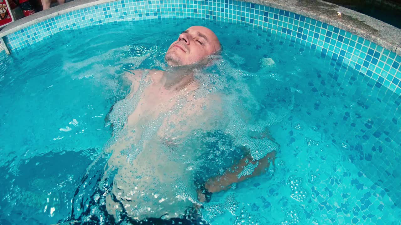地热温泉-秃顶男子放松在温泉池
