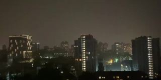 闪电掠过夜晚的城市。秋天的雷雨在城市里。晚上下大雨。