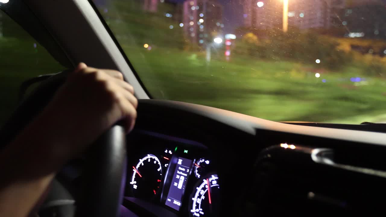 在城市夜间道路上行驶的汽车仪表板