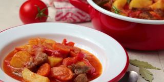 土豆和胡萝卜炖牛肉，加番茄酱，放在白色盘子里。