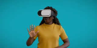 快乐年轻女性玩模拟游戏，使用VR头盔，增强现实