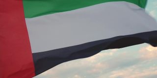 旗帜迎风飘扬，天空中布满了云彩，阿拉伯联合酋长国的国家象征。国庆日和阿联酋国旗日的概念