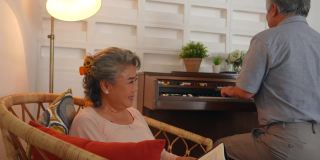 4K亚洲老夫妇一起在家里的客厅里弹钢琴和唱歌。