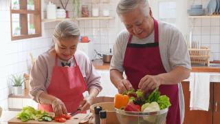 4K亚洲老夫妇一起在厨房做沙拉。视频素材模板下载