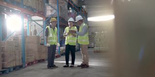 亚洲华人管理人员与仓库工人进行严肃的讨论与白帽使用数字平板电脑