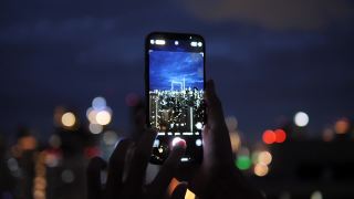 人们在一座建筑上拍摄城市的夜景。视频素材模板下载