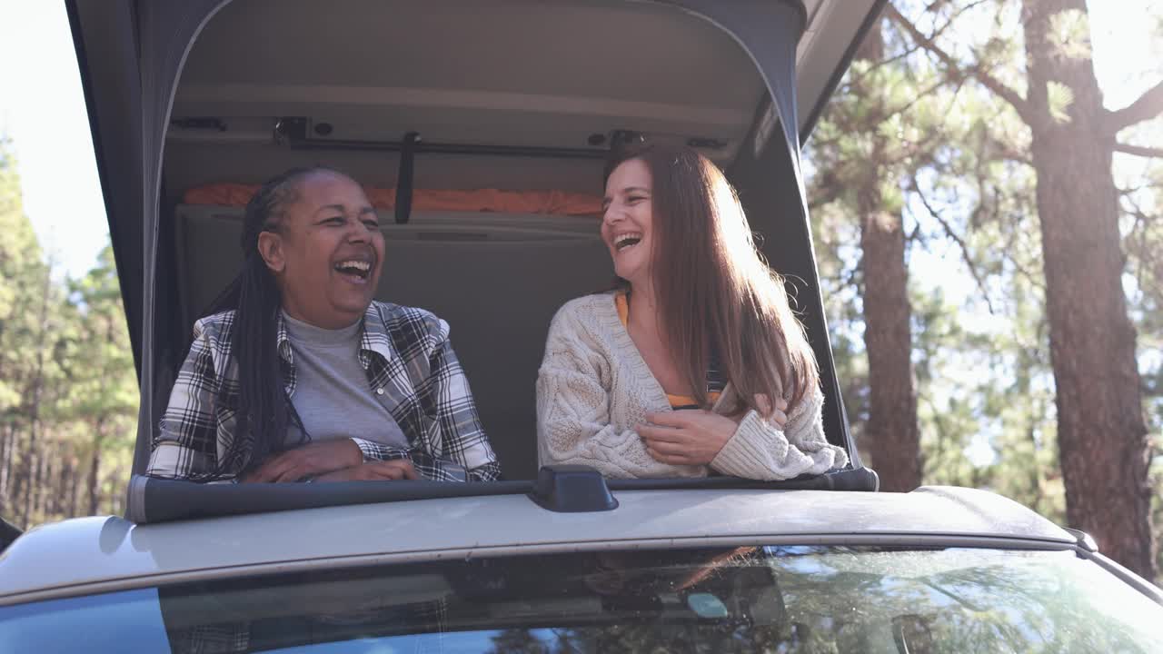 年长的女性朋友们开着野营车在山间旅行，享受大自然、多元种族和度假的乐趣