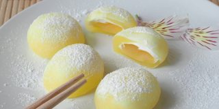白盘子里的麻糬。黄色的米饭甜点，麻糬大多是日本的传统甜食