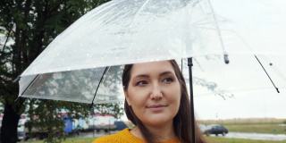 下雨天，一个女人在透明伞下的特写