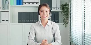 亚洲美女与人力资源经理视频电话面试。美女戴着耳机，用笔记本电脑与办公室公司进行虚拟在线会议讨论应聘工作。