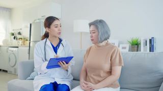 亚洲看护者心理医生仔细倾听耐心的女人。年轻漂亮的女护士在养老院检查和咨询帮助老年女性解决问题。心理卫生保健。视频素材模板下载