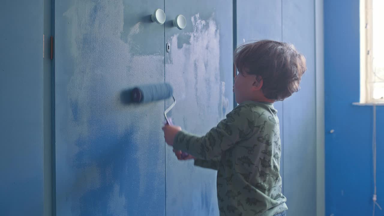 一个可爱的小男孩在家里粉刷房间的4k视频片段