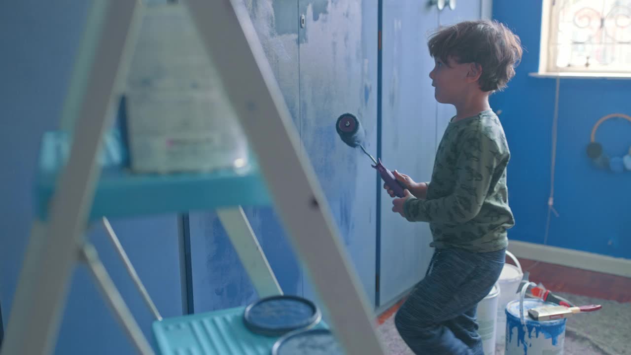 一个可爱的小男孩在家里粉刷房间的4k视频片段