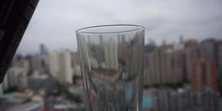 中国晒黑女孩在大城市的摩天大楼上倒泡沫啤酒。酒吧和餐馆重新开张，上海