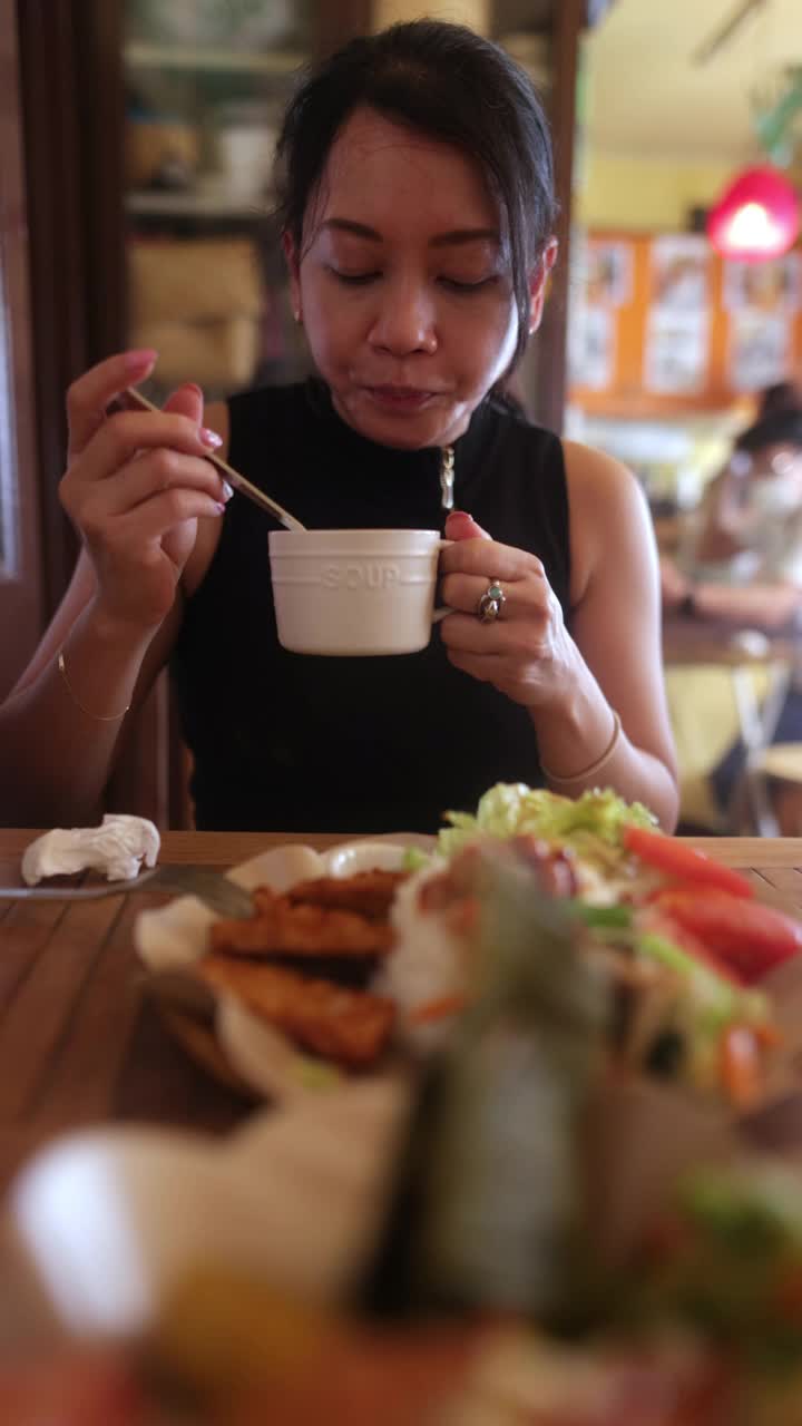 一位亚洲妇女在印尼餐厅吃午餐