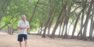 4K快乐的亚洲老人早上在海滩上锻炼。