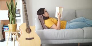 女人在休息时间在家里客厅的沙发上看书