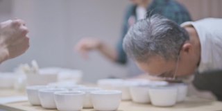 3名亚洲华裔男咖啡师品酒师表演杯咖啡，品尝杯咖啡后在剪贴板上写下
