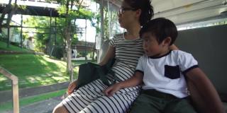 亚洲母亲和儿子在公园乘坐电车旅行
