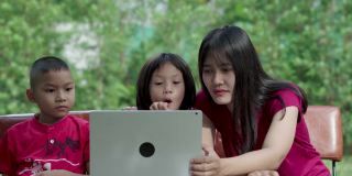 亚洲家庭喜欢在前院或后院里用笔记本电脑教学。