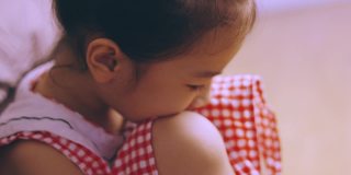 可爱的亚洲小女孩在卧室地板上孤独地哭泣，绝望、沮丧、沮丧和悲伤，这是由于家庭或学校的惩罚，这是暴力问题。
