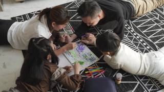 正上方的亚洲华人年轻家庭享受亲情时光，周末在家里的客厅公寓画画视频素材模板下载